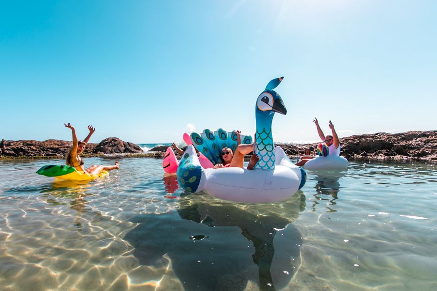 people floating in inflatables in the champagne pools on K'gari