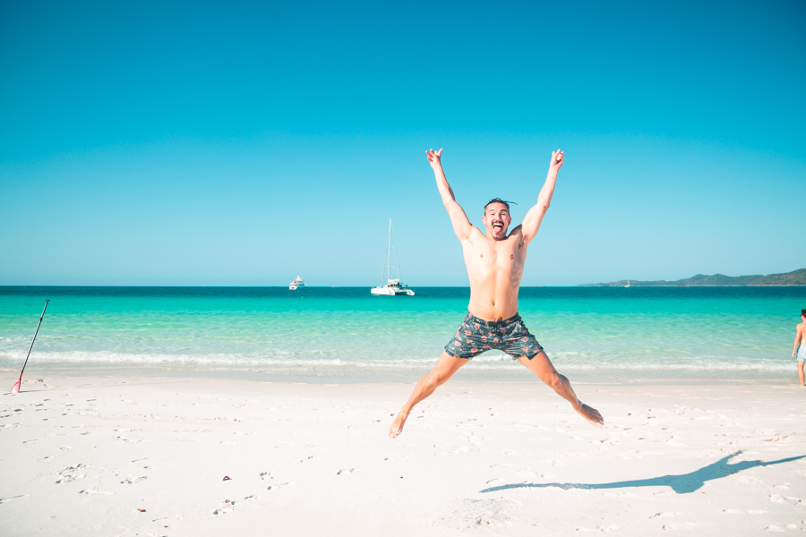 Jumping for joy on Whitehaven Beach Whitsundays.