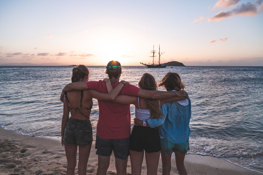 family hugging in front of sunset in the Whitsundays