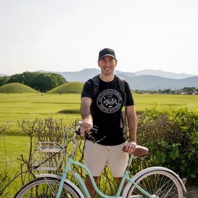 A man with a bike in a green field