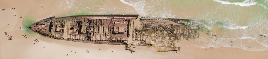 A birds eye view of a shipwreck on the sand