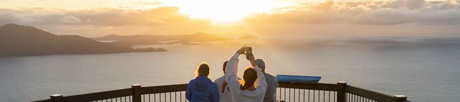 people overlooking the whitsunday islands and sunrise