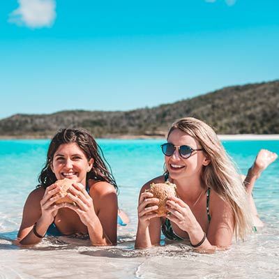 girls eating food on beach