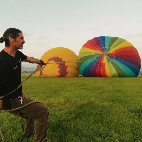 A man holding the rope of a hot air balloon