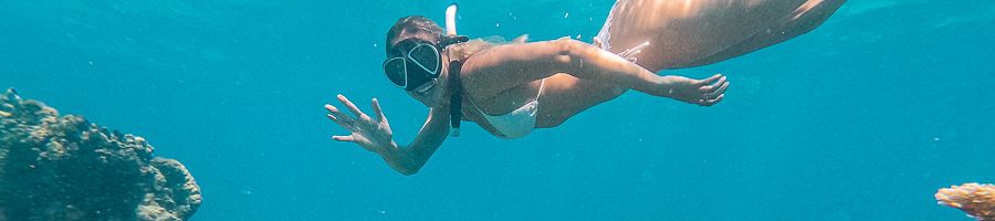 A woman snorkelling underwater on coral reefs