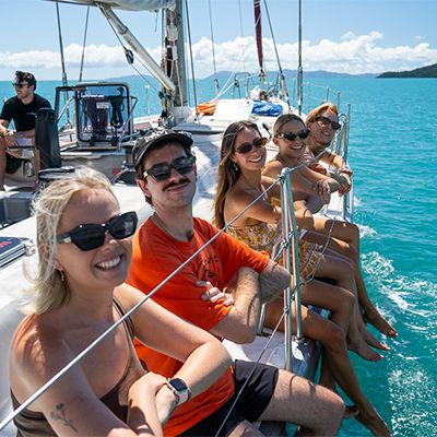 travellers sitting on the edge of a maxi yacht