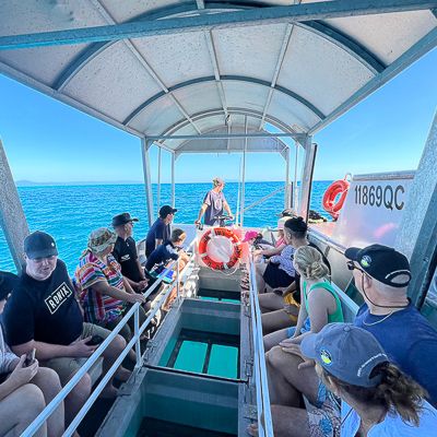 People sitting on a glass bottom boat on the reef