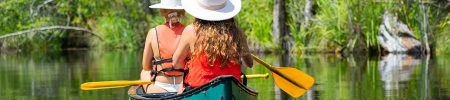 two girls in hats on a canoe tour around kgari