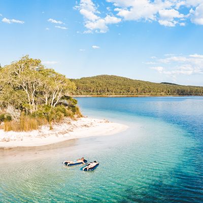 two travellers on floaties resting in lake mckenzie kgari