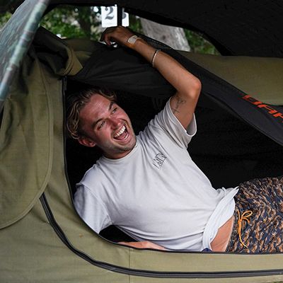 man smiling inside a swag camping tent on k'gari fraser island