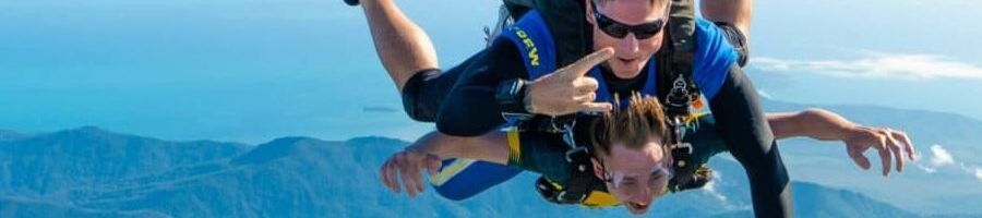 Two people skydiving over islands