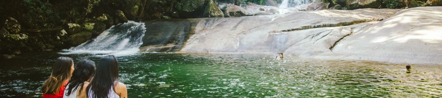 Three people relaxing at Josephine Falls, Cairns