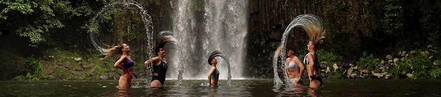 Group of people flicking their hair at Millaa Millaa Falls