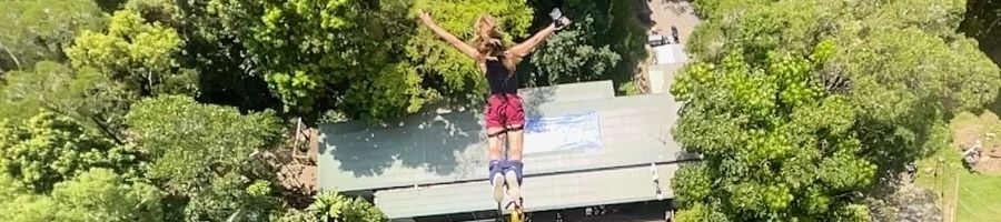 A woman doing a bungy jump in Cairns at Skypark by AJ Hackett