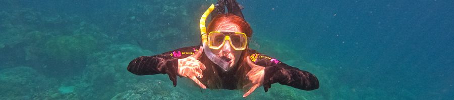 A woman posing for a camera while snorkelling on the Great Barrier Reef