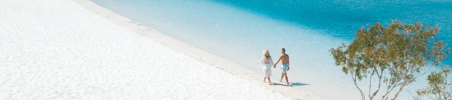couple walking along the shores of lake mckenzie