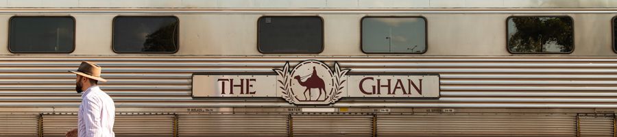 man walking past the ghan train in outback australia