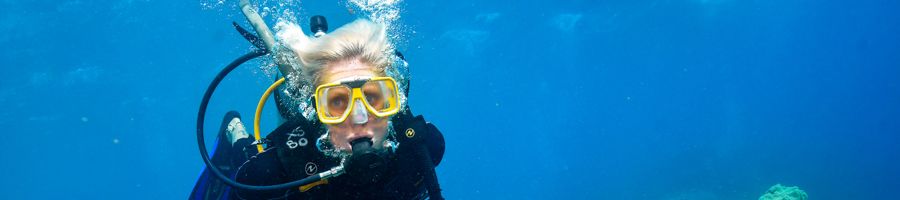 A blonde girl scuba diving at the outer reef