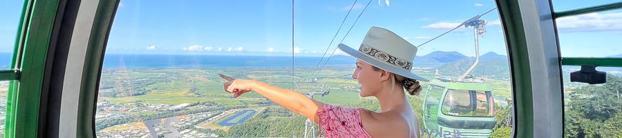 Women wearing a hat pointing at the scenic view aboard Skyrail Cairns