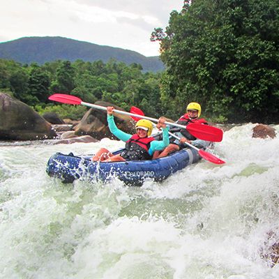 two people river rafting on a white water rapid