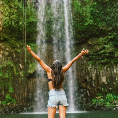 Woman with hands outstretched at Millaa Millaa 