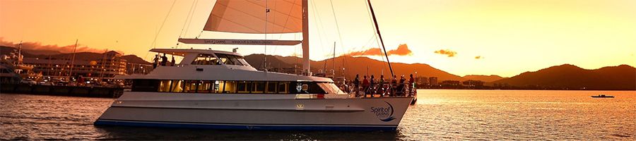 People aboard the Spirit of Cairns catamaran at sunset
