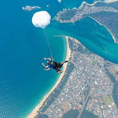 A guy and a professional skydive tandem buddy soaring through the sky