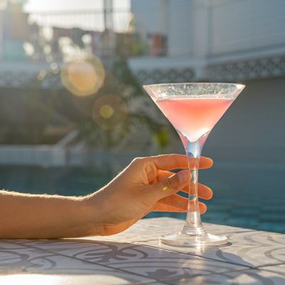 Pink cocktail with a hand holding the glass