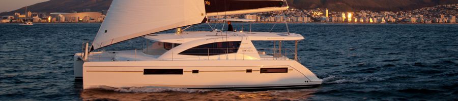 A catamaran at sail during sunset