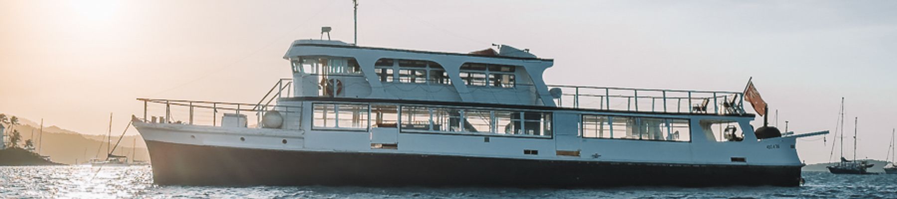 A large boat on the ocean at sunset