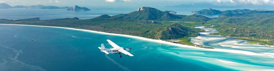 seaplane flying over Whitehaven Beach