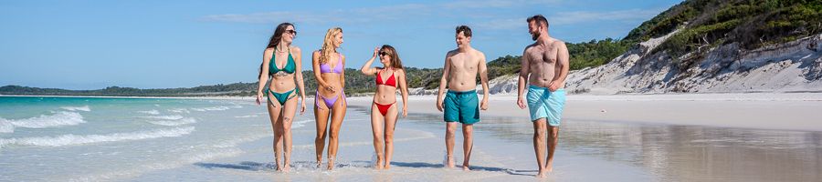A group of young backpackers walking on Whitehaven Beach