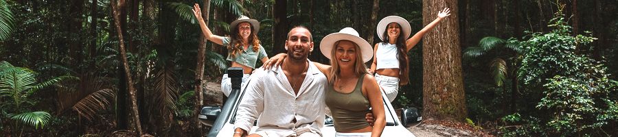 A group of backpackers in a white Pippies 4WD in the forest