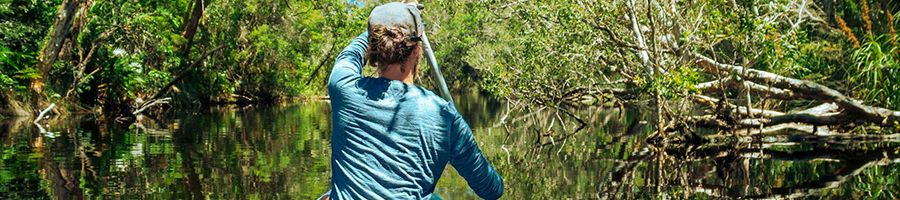 Man canoeing through streams