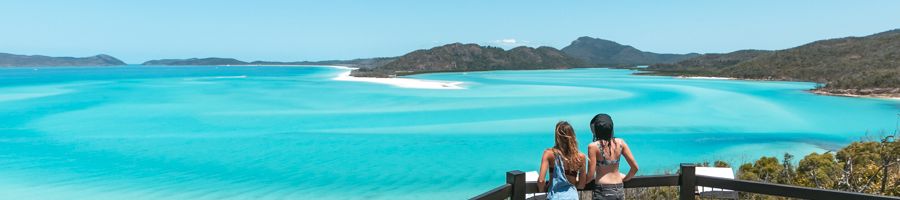 Two people looking at Hill Inlet Lookout views of blue waters and white sands