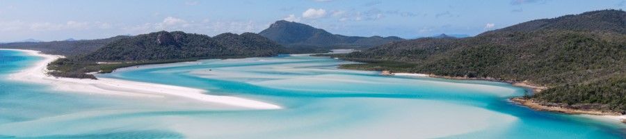 Aerial view of Whitsundays, white sands, green mountains, aqua waters