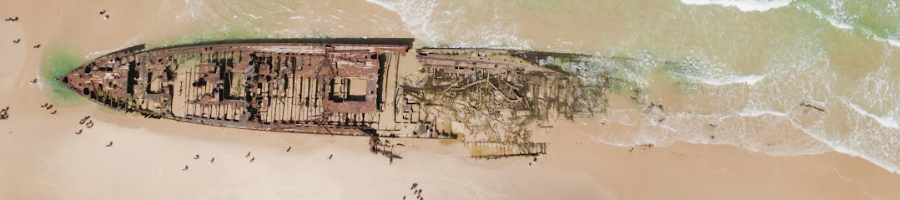 A top down shot of a shipwreck washed up on the beach