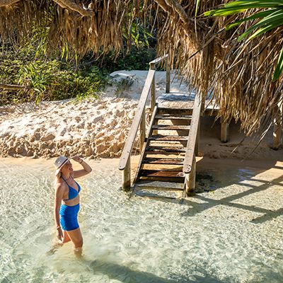 girl walking through the water at eli creek k'gari