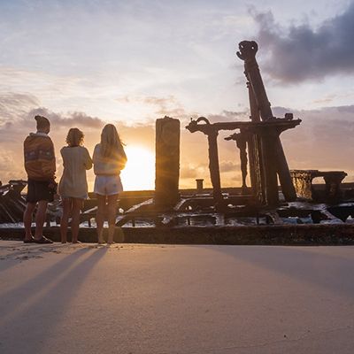 Three backpackers watching the Maheno Shipwreck sunrise