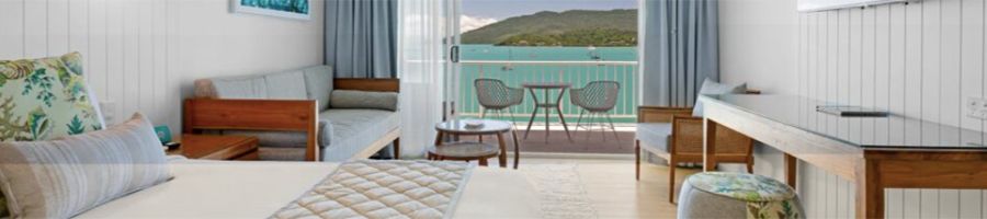 bed and a balcony looking out to sea at coral sea resort