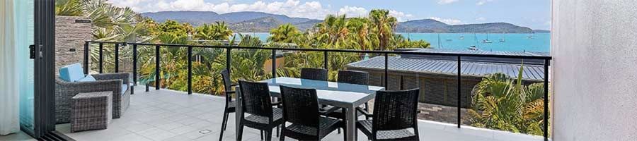 balcony table set up in front of the blue coral sea