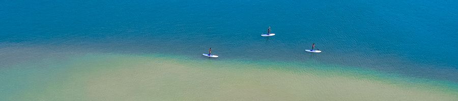 paddleboards drifting along bright blue water