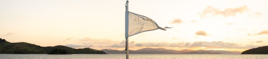 a flag on the back of a yacht that says 'Alani'