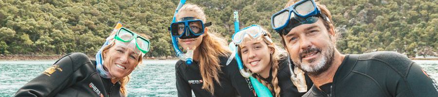 family in snorkel gear on the great barrier reef australia