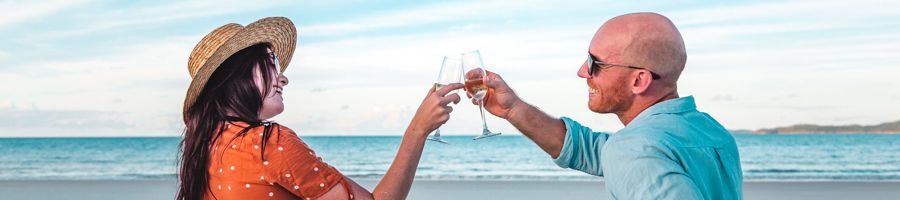 Couple with champagne on a beach picnic