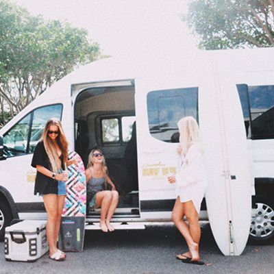 A group by the van with surfboards and smiles