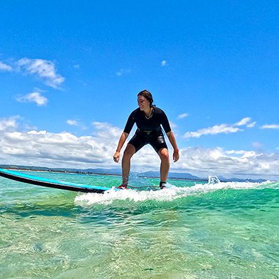 Kirra Beach surf lesson with a person in a wetsuit on blue surf board