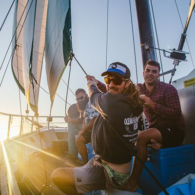 Three men on a boat sailing 