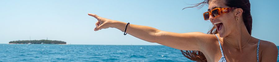 girl pointing at green island from a boat