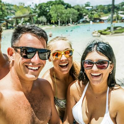 Three backpackers smiling by the lagoon for a selfie